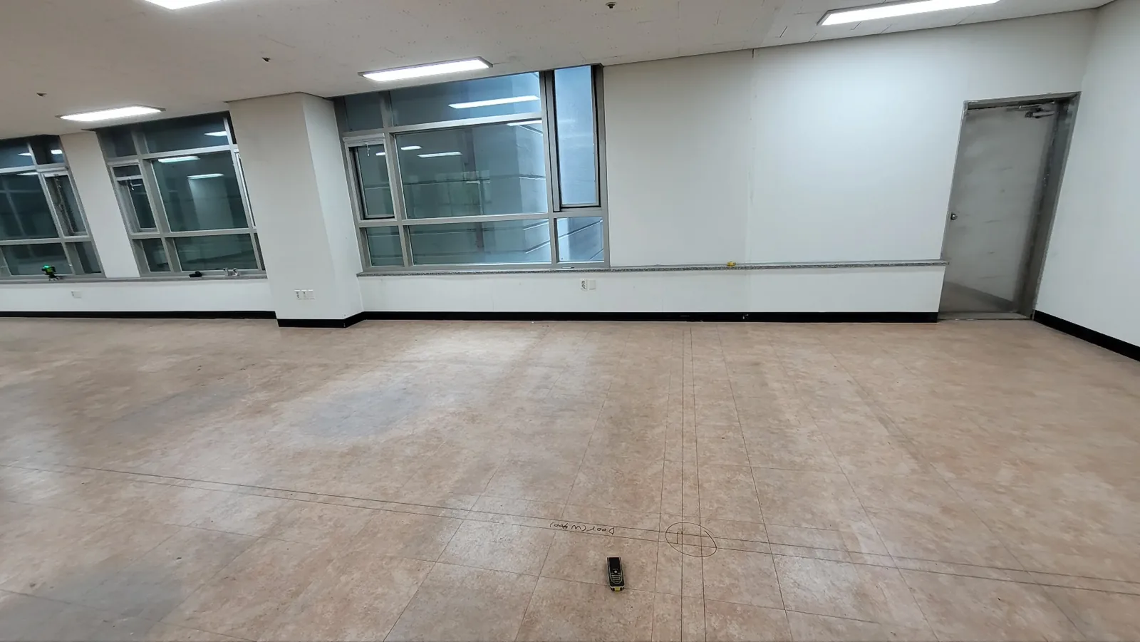 유리칸막이 시공 전 비어있는 사무공간 바닥 실측 표시